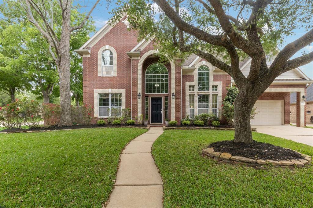 Charming brick elevation with soaring two-story entryway welcomes you home to this beautifully maintained residence in the heart of Greatwood. Mature trees, lush landscaping, and an inviting walkway set the tone for the warmth and comfort found inside.