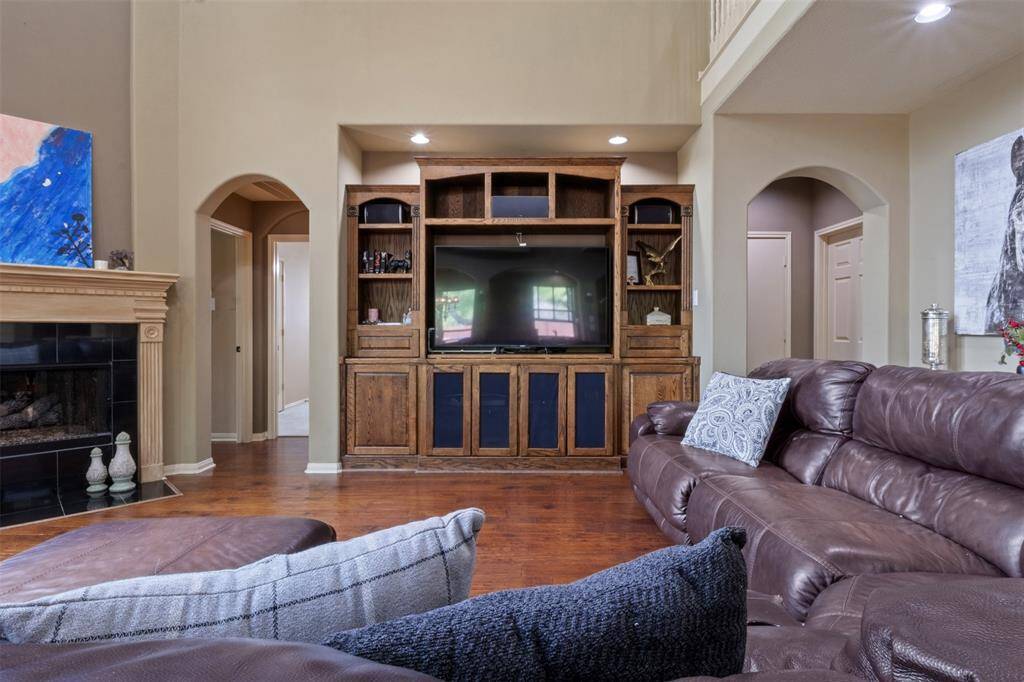 Designed for everyday enjoyment and weekend movie nights, the living room features a custom built-in entertainment center and a warm fireplace that anchors the space. Whether relaxing solo or gathering with guests, comfort and connection are at the forefront.