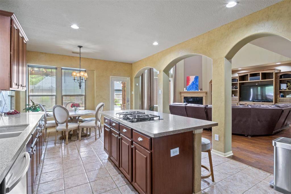 From morning coffee to evening gatherings, this open-concept kitchen flows effortlessly into the living room and breakfast nook. Arched pass-throughs, natural light, and a central island with bar seating create a space that’s equal parts functional and welcoming.