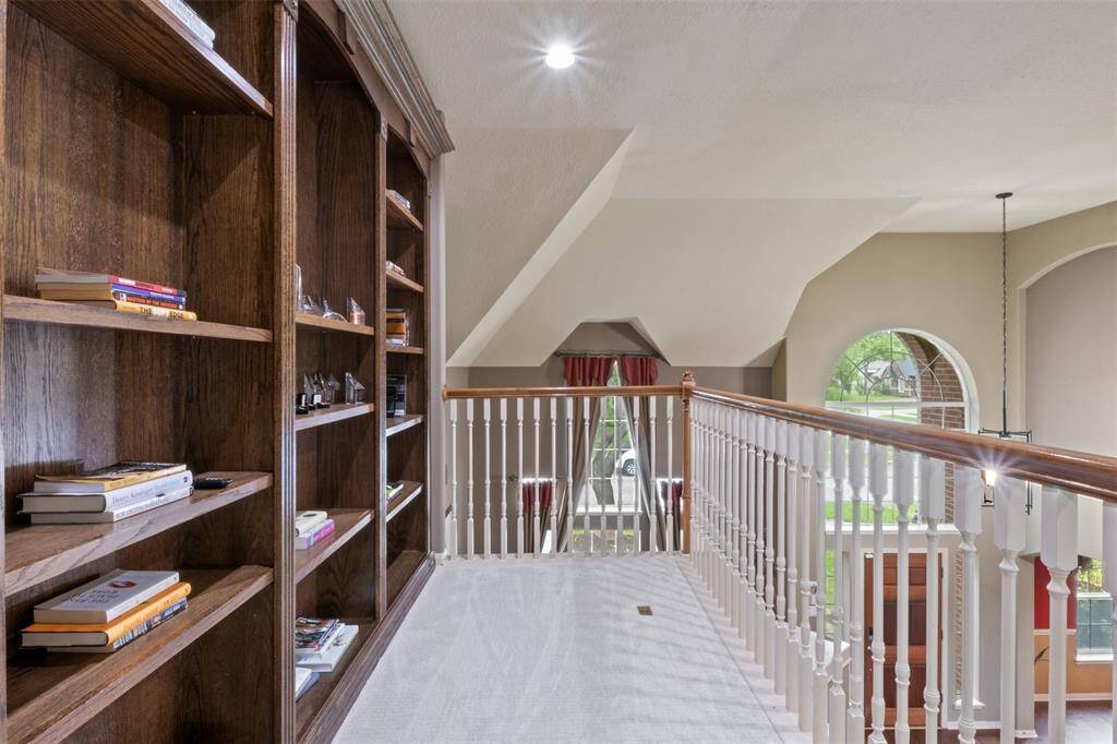 Tucked along the upstairs landing, this built-in library offers the perfect spot to showcase your favorite reads or display treasured pieces. Overlooking the grand entry below, it adds charm and character to the home’s upper level.