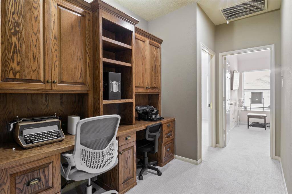 Tucked away on the upper level, this built-in dual desk area provides the ideal setup for remote work, homework, or creative pursuits. With abundant cabinetry and shelving, organization and productivity come naturally in this well-appointed space.