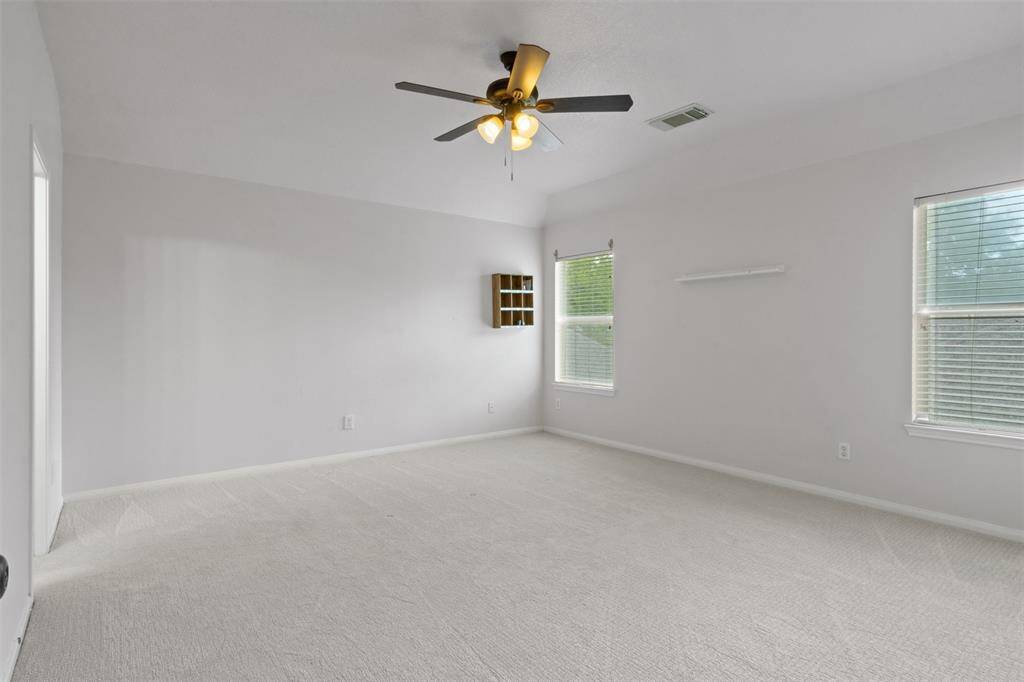 One of the spacious upstairs bedrooms, this light-filled retreat features fresh carpet, neutral tones, and ample room for personalized furnishings—ideal for family, guests, or a private home office.