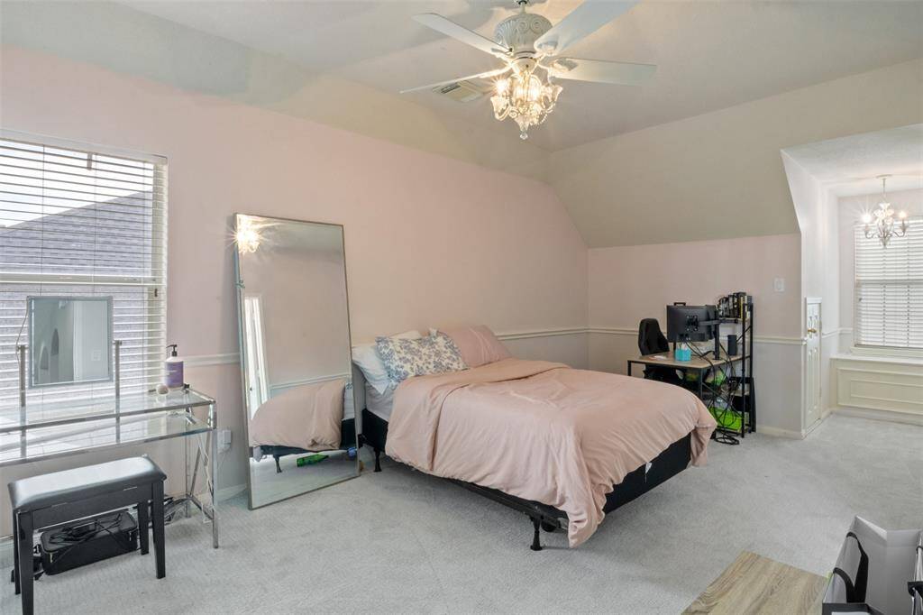 One of the spacious upstairs bedrooms, this charming space features soft natural light, a unique window nook with built-in storage, and enough room for both rest and productivity.