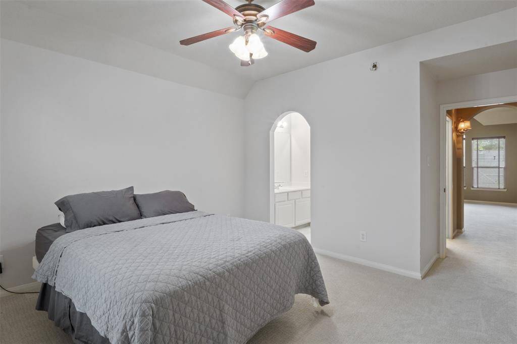 This serene upstairs bedroom includes a private ensuite vanity area, offering comfort, privacy, and convenience—perfect for guests or family members seeking a quiet retreat.