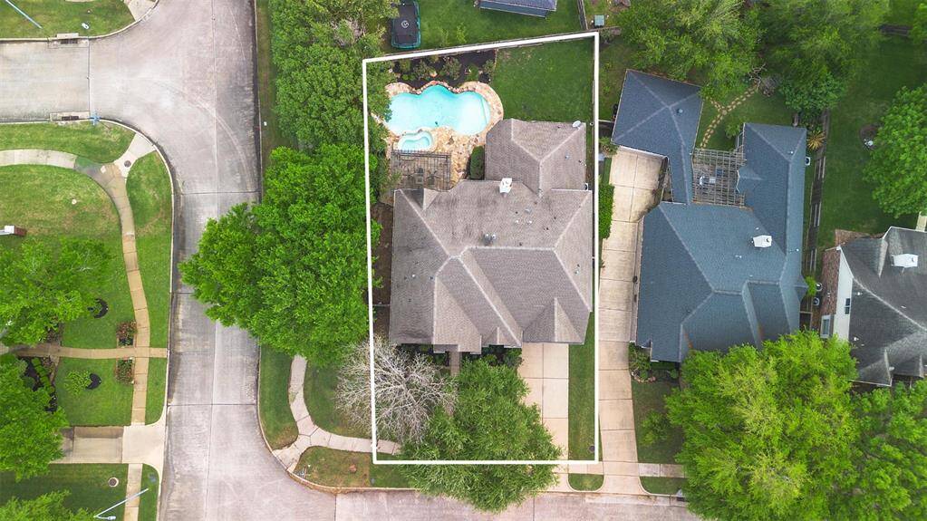 Aerial view of the property showcasing its spacious lot, private driveway, and beautifully landscaped backyard complete with a pool, spa, and covered patio. Located on a quiet cul-de-sac in the Greatwood community.