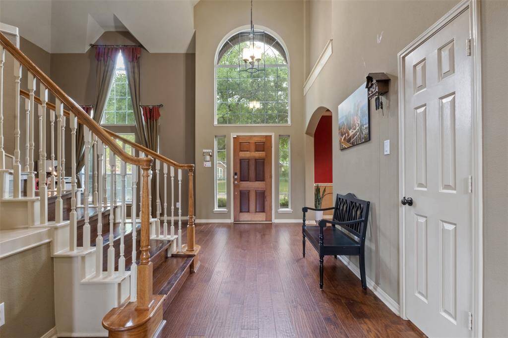 Step inside to a soaring two-story foyer filled with natural light, rich hardwood floors, and an elegant staircase that instantly elevates the ambiance. This inviting entry sets the stage for a home designed to impress and built for comfortable living.