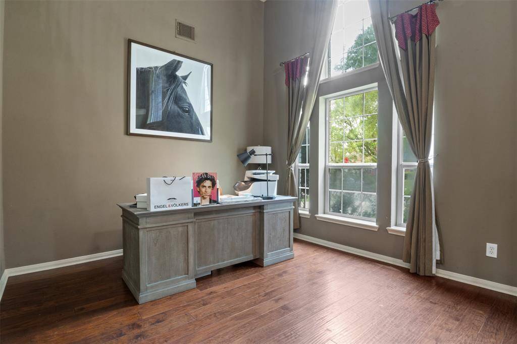 Sunlight pours through floor-to-ceiling windows, creating an inspiring atmosphere for productivity in this dedicated home office. Whether working remotely or pursuing creative projects, this space offers tranquility, focus, and a connection to the lush outdoors.