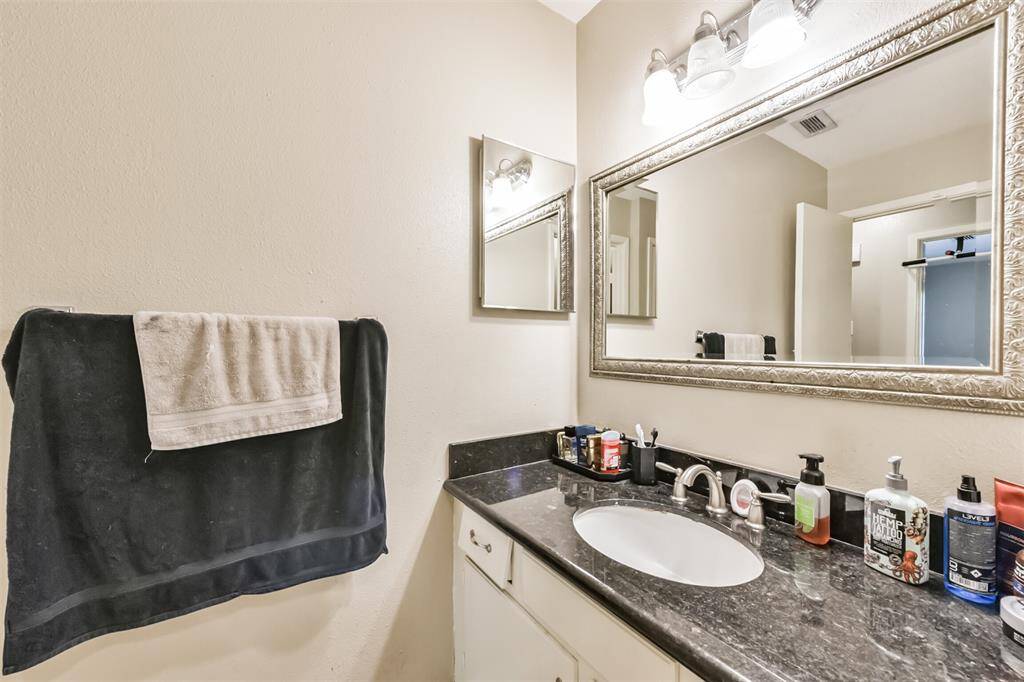There are granite counters and a framed mirror in the full bathroom.
