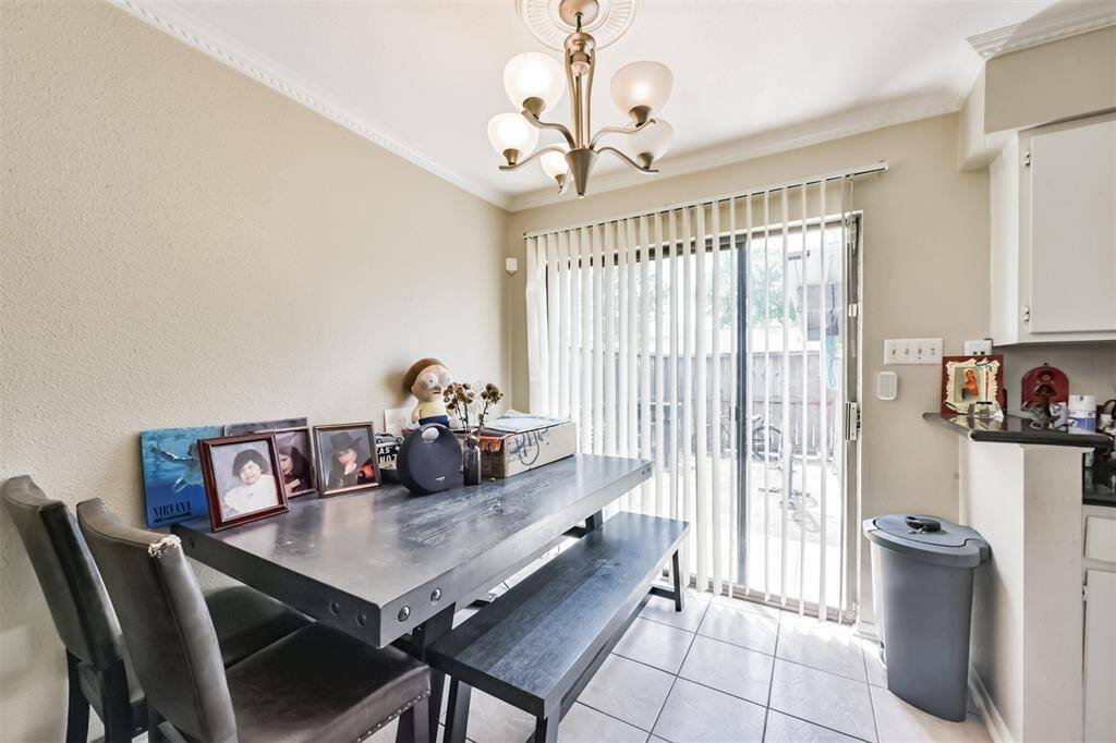 The dining area has crown molding, tile floors and access to the back patio through the sliding glass door.