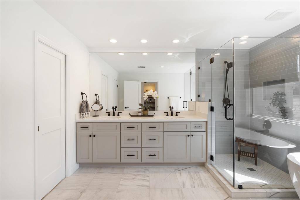 The primary bathroom features quartz countertops, a large walk-in shower, soaking tub, and a generous closet with custom built-ins.