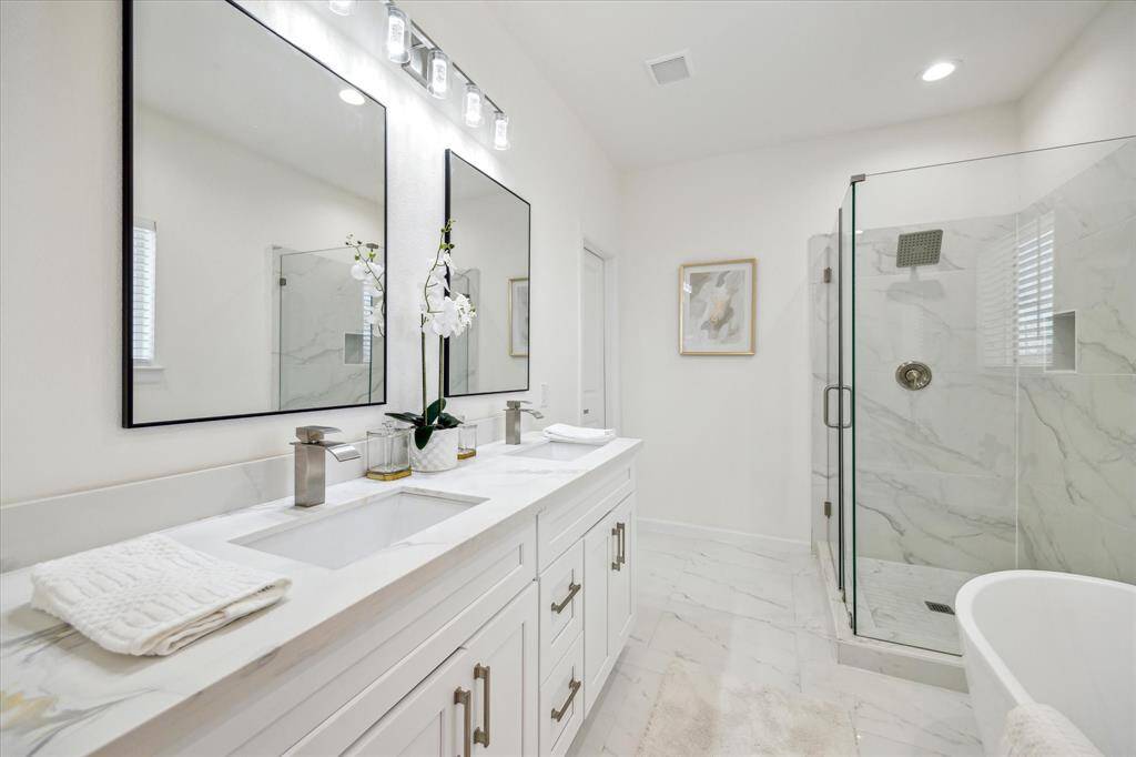 Primary bathroom suite with separate tub and shower and double vanity