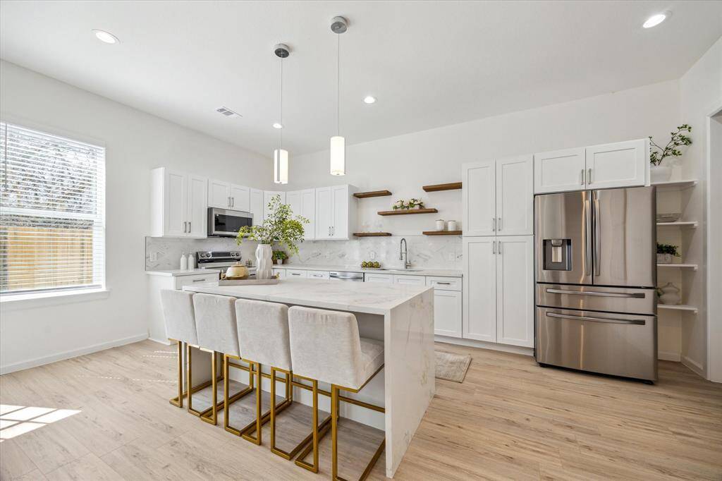 Gourmet kitchen with stainless steel appliances, quartz countertops, and ample storage