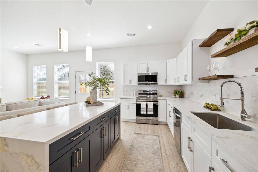 Gourmet kitchen with stainless steel appliances, quartz countertops, and ample storage