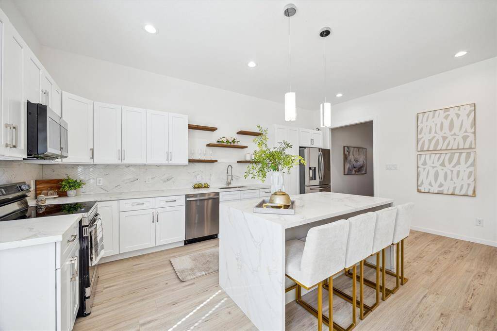 Gourmet kitchen with stainless steel appliances, quartz countertops, and ample storage