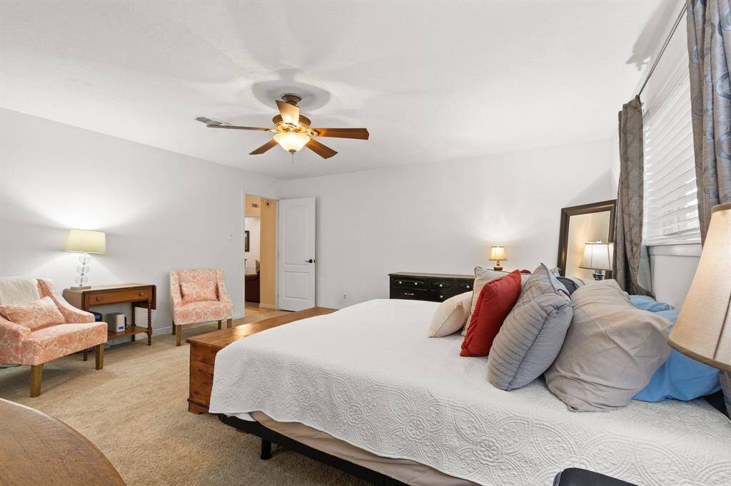 This spacious primary bedroom features a comfortable layout with a King size bed, and ample natural light. It includes a ceiling fan, soft carpeting, and neutral tones for a relaxing atmosphere.