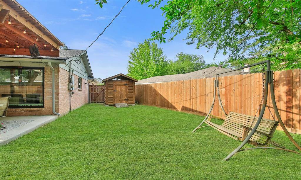 This backyard features a well-maintained lawn, and a shed!