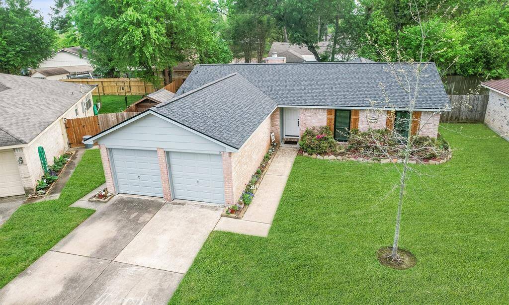 This charming single-story home features a brick exterior, a well-maintained front yard with lush grass, and a two-car oversized garage. Extra spce up front for a work bench or bike storage.  The property includes mature trees and a neat garden bed lining the pathway to the front entrance. It's situated in a quiet neighborhood with fenced-in backyard spaces.