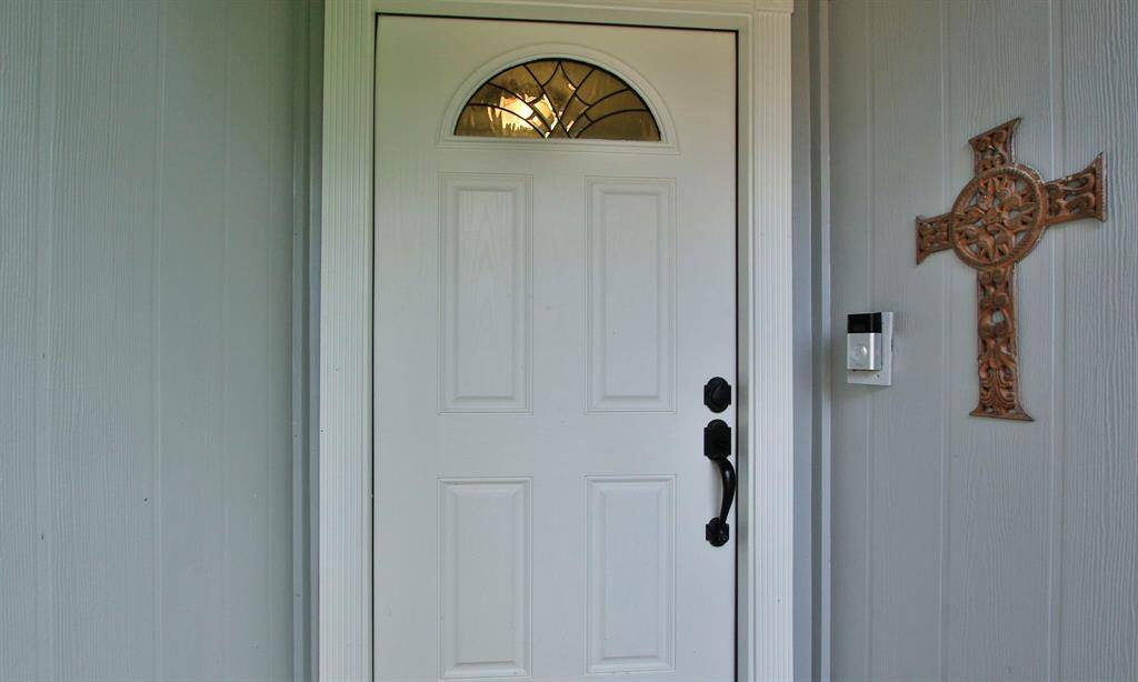 A welcoming front door with a decorative window panel and a classic handle.