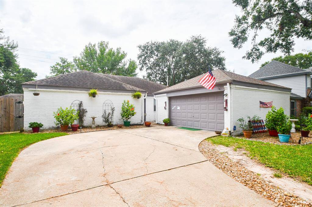 This is a single-story home featuring a white exterior with a two-car garage, a well-maintained front yard.