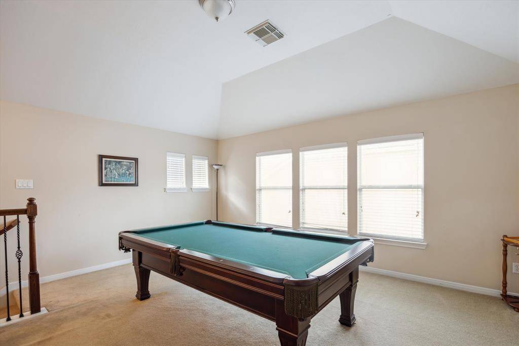 Upstairs is the Media and Game Rooms along with 1/2 bathroom. The pool table will remain for you to enjoy!   There are high vaulted ceiling in this room.