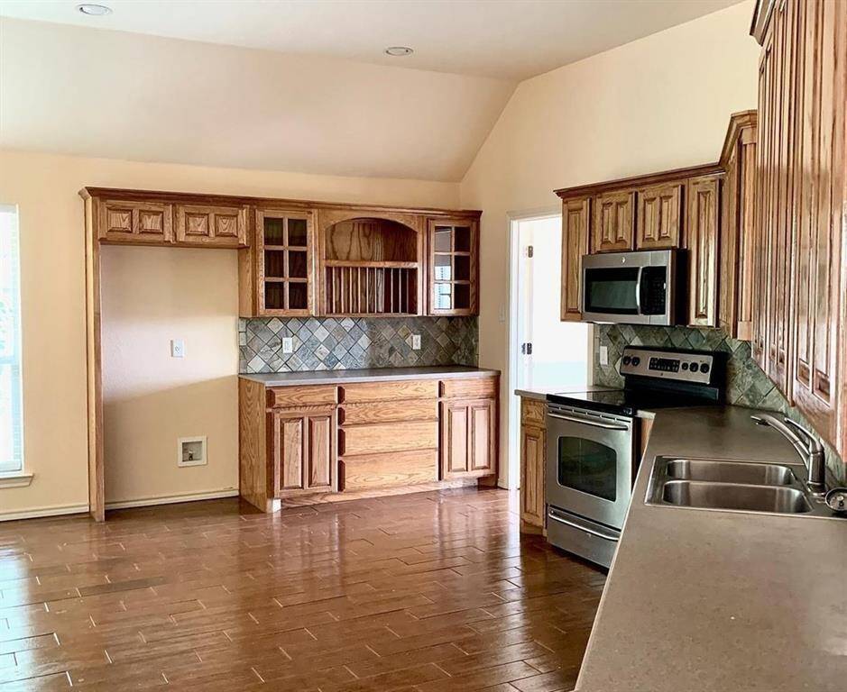 At the heart of the home, the gourmet kitchen is equipped with abundant countertops and cabinetry, stainless steel appliances, and a spacious walk-in pantry for storage.