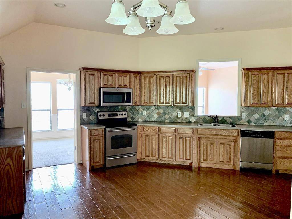 The kitchen seamlessly connects the dining and living rooms, demonstrating how this space is well-positioned for interaction with family or friends even while cooking.
