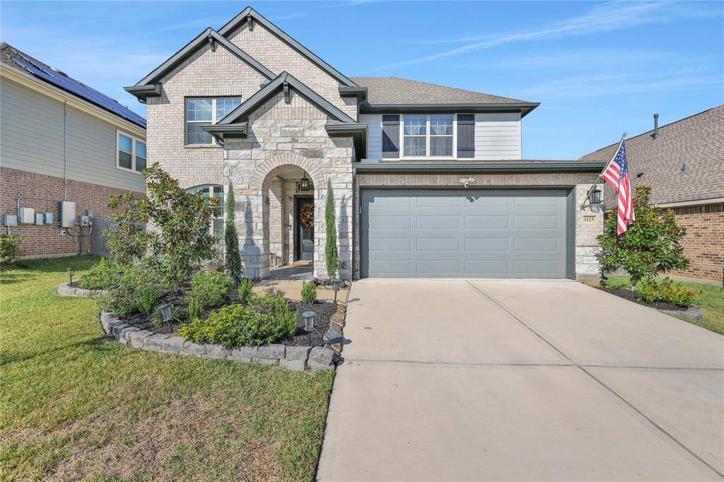 Discover elegance in this charming two-story residence boasting a stately stone and brick exterior, complete with a spacious two-car garage and a beautifully manicured front yard.