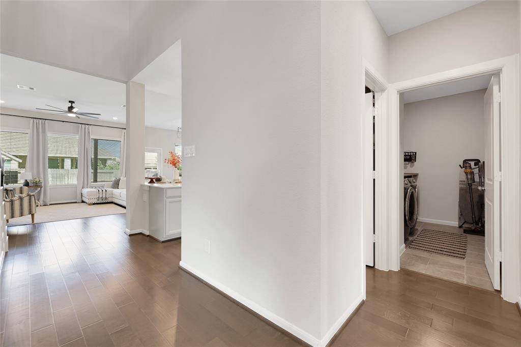 The entrance features an open-concept living space with a seamless transition to a well-lit family room. To the right is a convenient laundry room, adding to the practical layout of the home. The interior features neutral tones, providing a versatile backdrop for personalization.