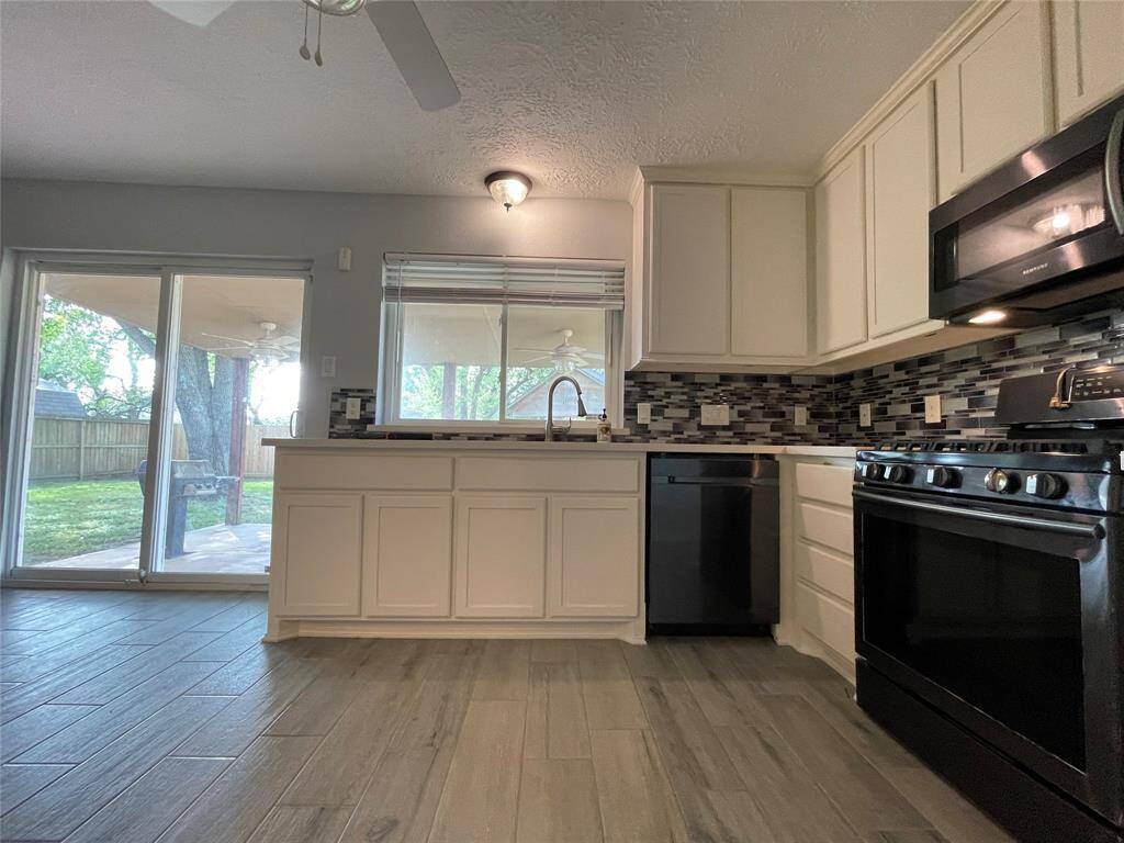 Kitchen features include white cabinets, quartz countertops, Samsung appliances and a stainless steel sink with pull-out faucet.