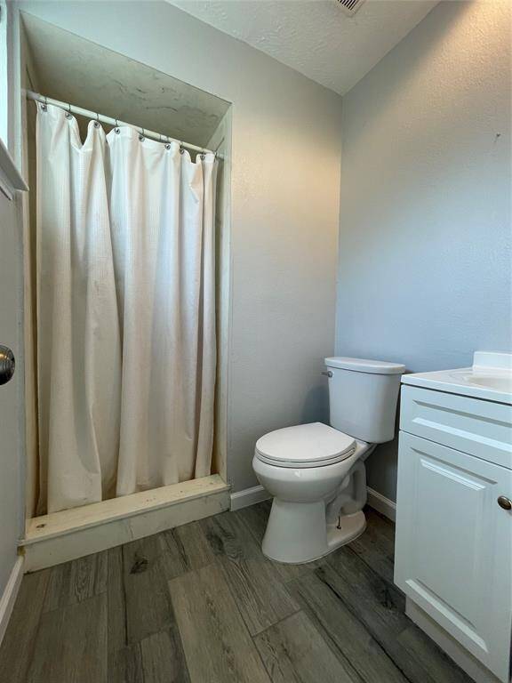 Primary bath features a shower, single sink vanity and tile floors.