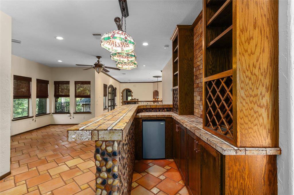 The upstairs bar has custom cabinetry and a "bevfridge"