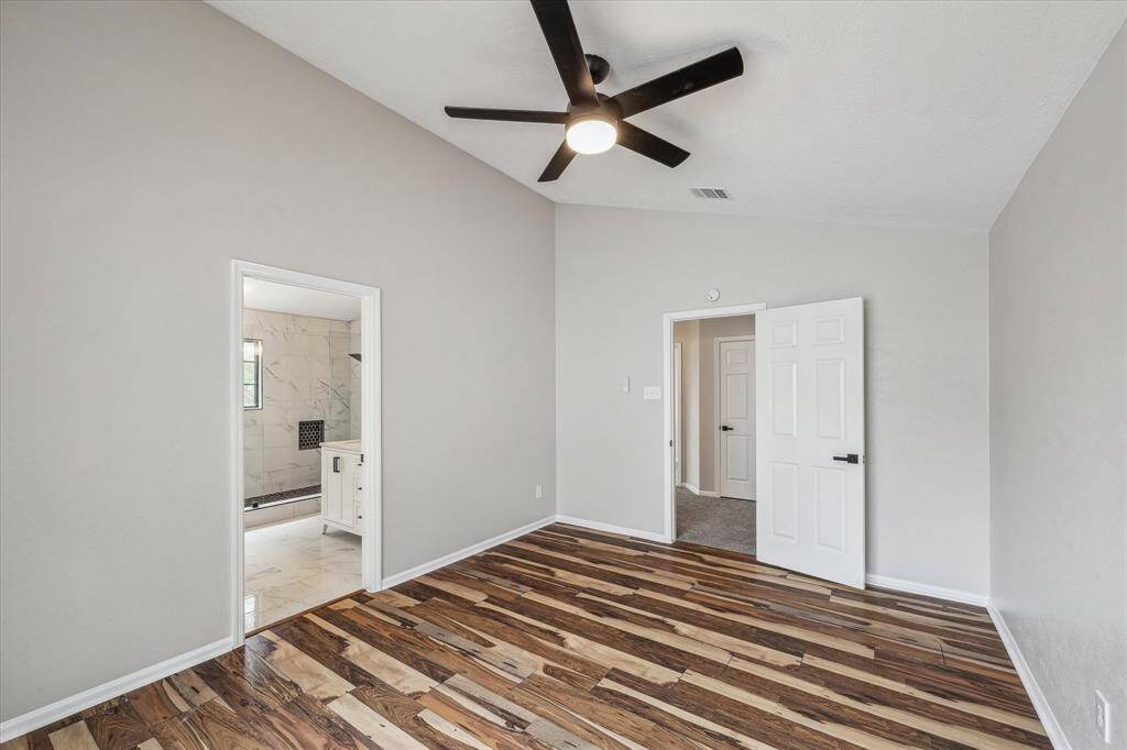 The primary bedroom  has fresh paint, new ceiling fan and flooring.
