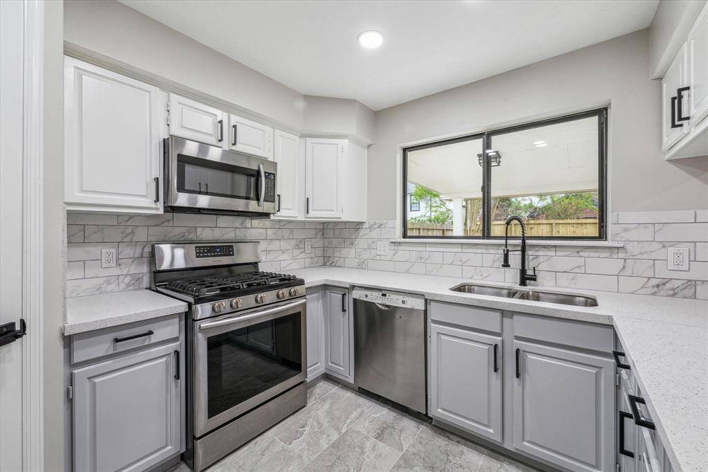 This kitchen has been updated beautifully.  New granite counters, tile backsplash, sink, tile flooring, & painted cabinetry w/new hardware.