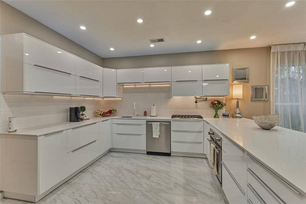 This chic and lavish kitchen boasts of all new cabinetry, updated lighting, hardware and backsplash.
