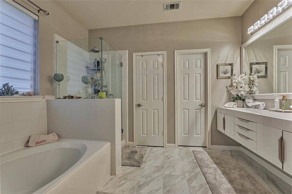 The updated primary ensuite features new tile flooring and a floating vanity with dual sinks.