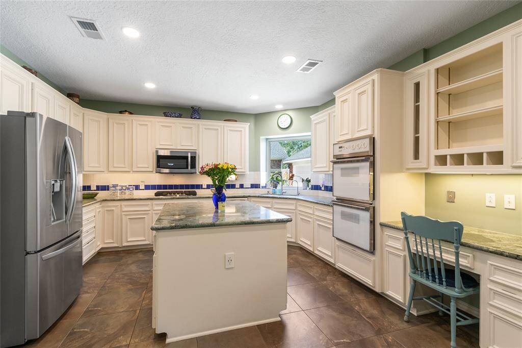 The kitchen is bright and light with a built in desk and large center island. The refrigerator stays.