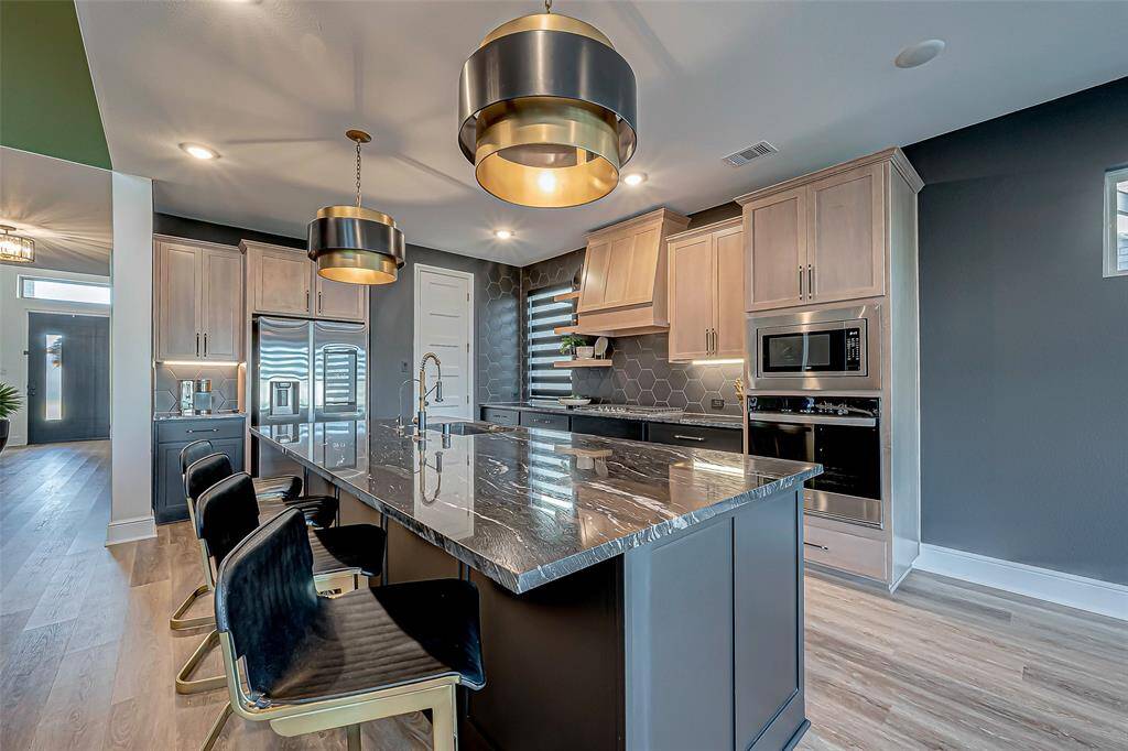 The kitchen is a chef’s dream, featuring a large central island that provides ample space for meal preparation and casual dining. Equipped with high-end stainless steel appliances, it combines style and functionality.