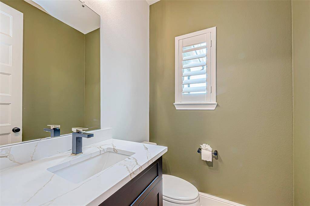 This convenient half bathroom is located on the downstairs level, offering both style and functionality. Featuring modern fixtures and a sleek vanity, it provides a practical space for guests without compromising on design.