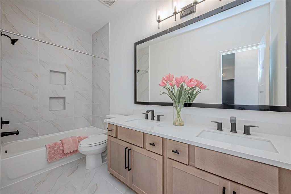 The third bathroom is both functional and stylish, featuring double sinks that provide plenty of space for shared use. The tub-shower combo offers versatility, making it easy to unwind in the tub or enjoy a quick shower.