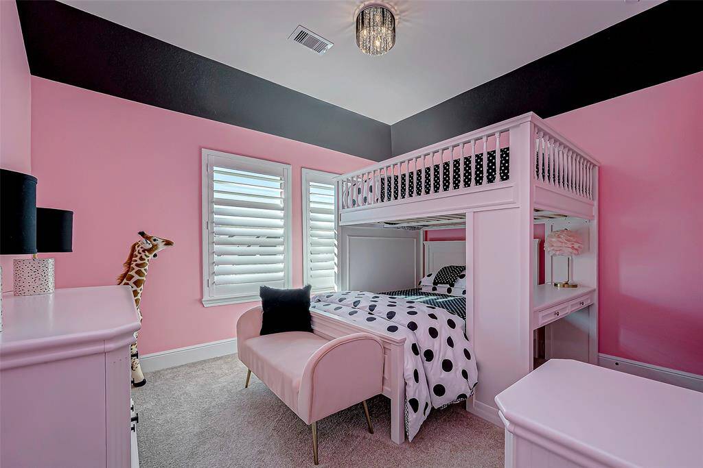 The charming third bedroom features a playful yet sophisticated design, with soft light pink walls complemented by bold black accents. This striking color combination creates a cozy and stylish atmosphere, perfect for relaxation or creative activities.