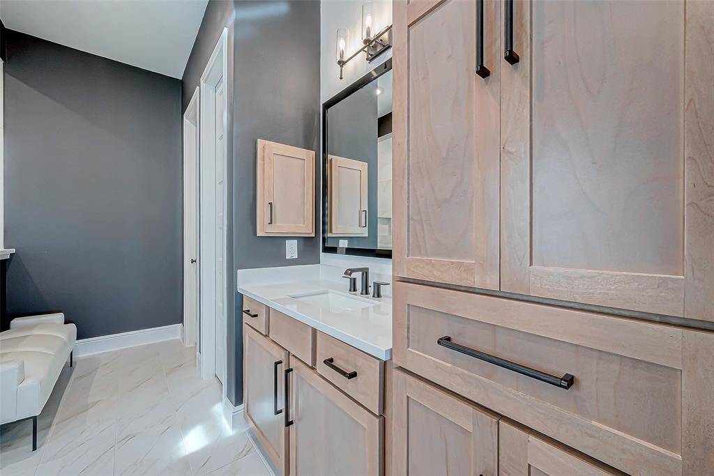 The luxurious primary bathroom is designed for both relaxation and functionality, featuring dual vanity areas that provide ample space for personal use. A cozy sitting area offers the perfect spot to unwind, while the oversized shower provides a spa-like experience with plenty of room to relax.