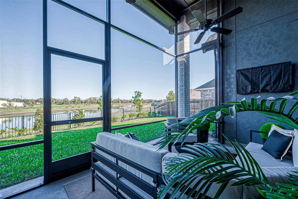 The inviting covered and enclosed patio offers a perfect space for outdoor relaxation, featuring a ceiling fan to keep the breeze cool on warm days. It overlooks the serene lake, providing breathtaking views and a peaceful atmosphere.