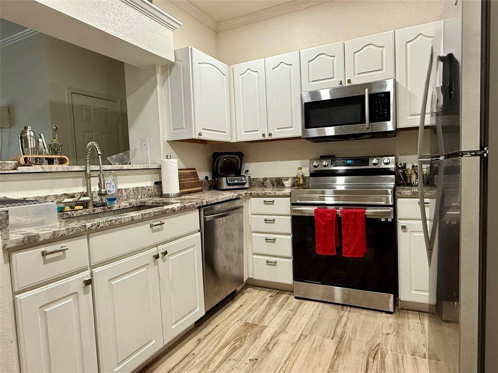 Remodeled kitchen with many new appliances, granite countertops and luxury vinyl flooring