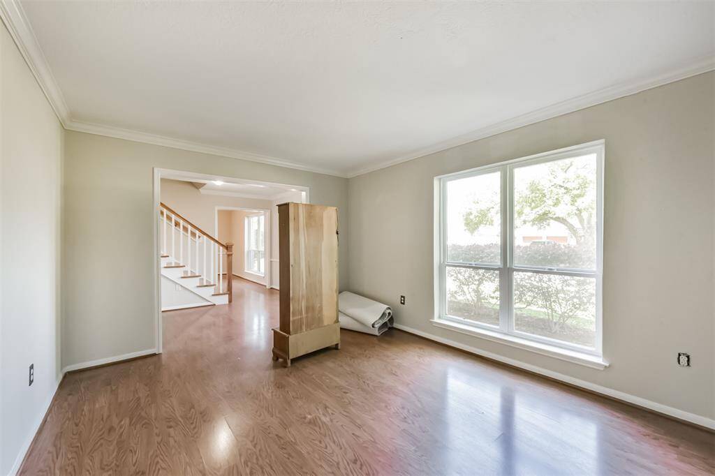 The formal living room showcases laminate floors and crown molding.