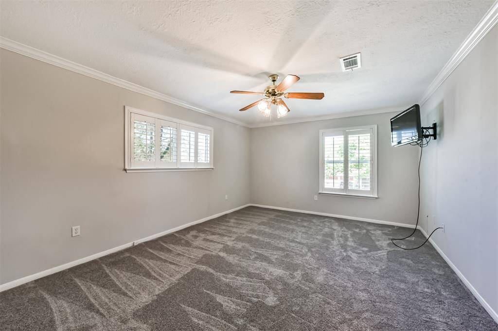 The primary bedroom is located on the second floor with recent carpet floors, crown molding, a ceiling fan and plantation shutters.