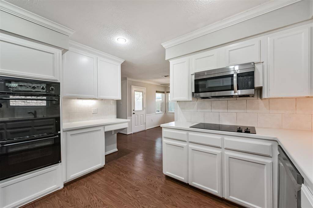 This view of the kitchen shows the double oven, built-in microwave and electric cooktop.