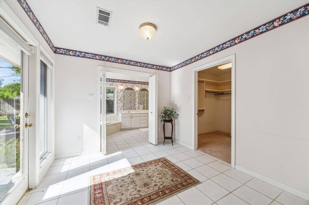 This quaint space in between the Primary Bedroom and Bathroom would be great as an exercise space or sitting area with door leading to patio.
