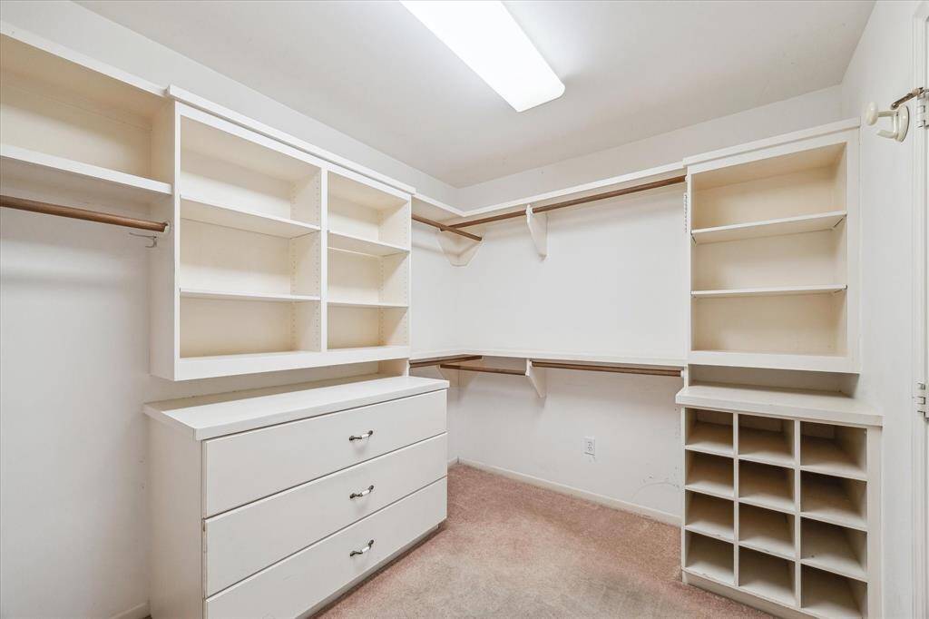Primary closet is quite large for a home built in 1965! These owners thought of everything- even shoe cubbies!