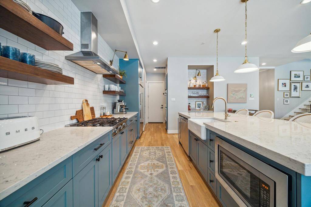 At the opposite end of the kitchen, you'll find a built-in KitchenAid refrigerator, double Bosch wall ovens, and a spacious walk-in pantry.
