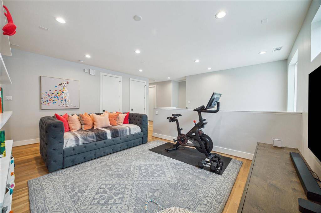 At the top of the stairs, the game room offers a versatile additional living space, complete with hardwood flooring and recessed lighting. Two extra-large storage closets ensure ample space for games, toys, and seasonal items. Not photographed is the large walk-in utility room (located down the hall to the left) with stainless steel utility sink, metal hanging rack and accommodates full-size, side-by-side washer and dryer.